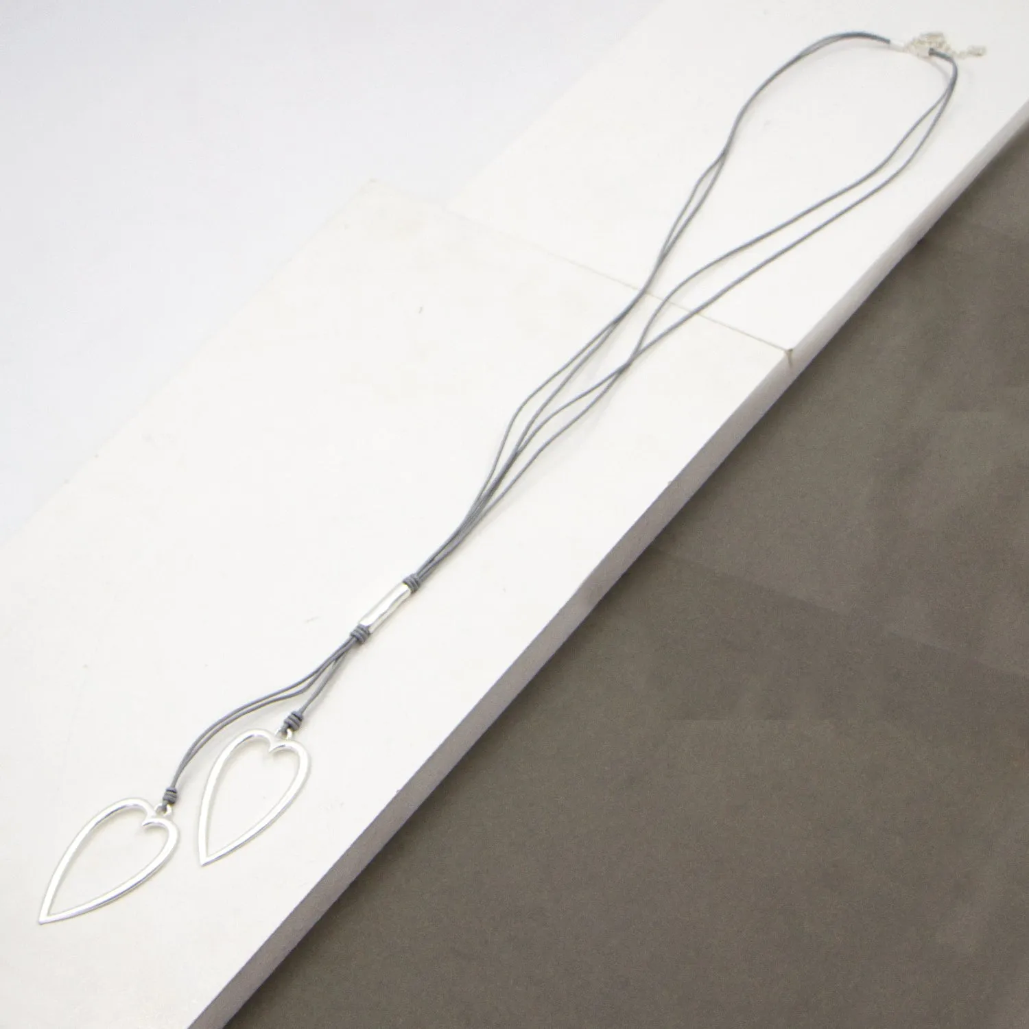 Elongated twin heart pendants on long multi leather necklace