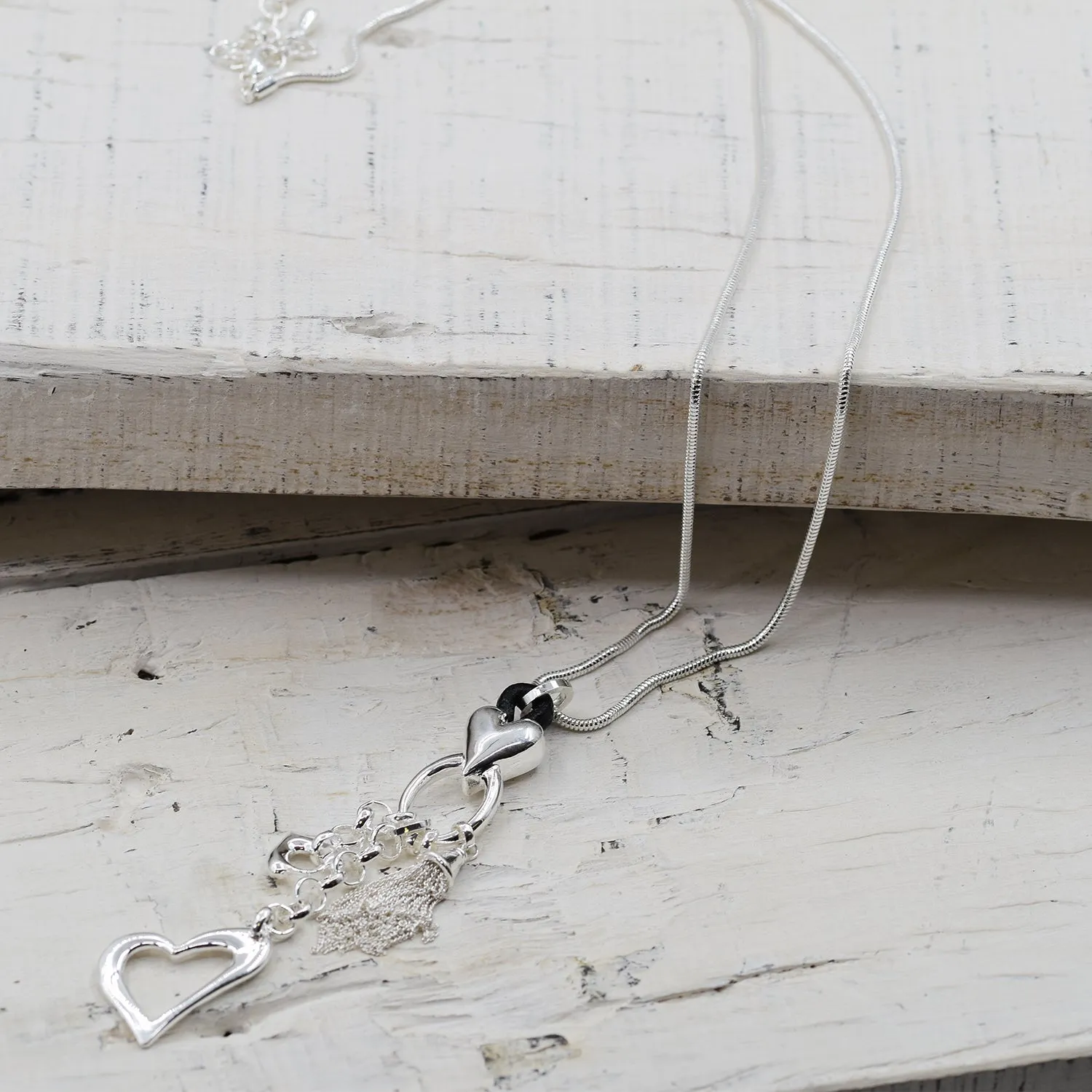 Heart and tassel pendants with leather component on long sna